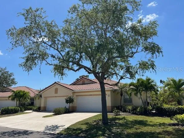 a front view of a house with a yard and tree