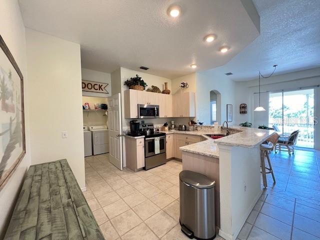 3181 Matecumbe Key Road, Unit 10 Punta Gorda, FL 33955 - Photo 16 of 52 a large white kitchen with a large window appliances and furniture