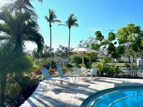 a view of a backyard with table and chairs under an umbrella