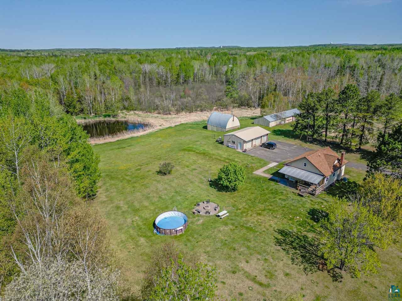 2581 O'Rourke Road Hibbing, MN 55746 - Photo 57 of 61 Expansive property featuring a detached residence with a covered porch, multiple outbuildings, a private pond, and ample green space