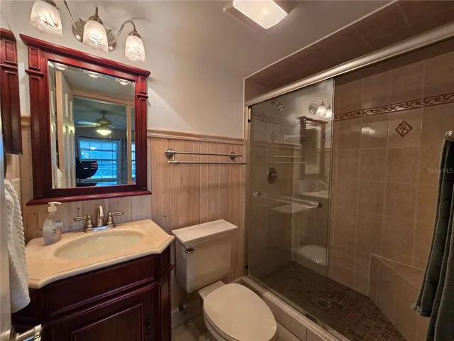 a bathroom with a sink a toilet a mirror and shower