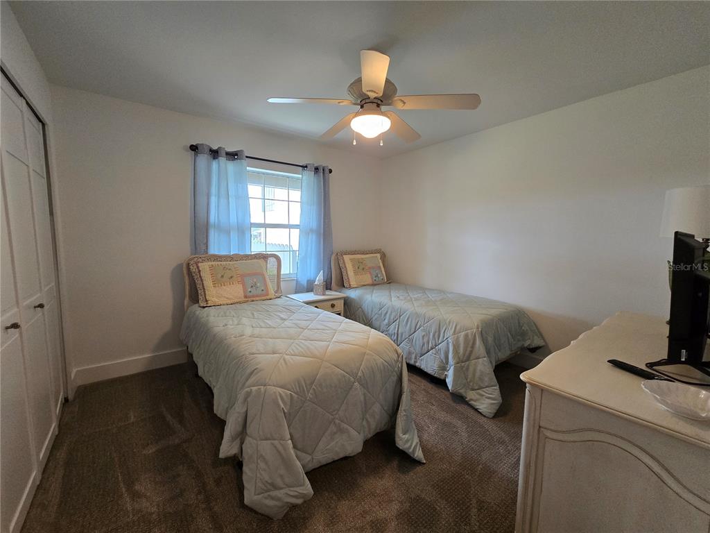 1640 Juno Trail, Unit 103C Astor, FL 32102 - Photo 12 of 20 a bedroom with two beds and a flat screen tv