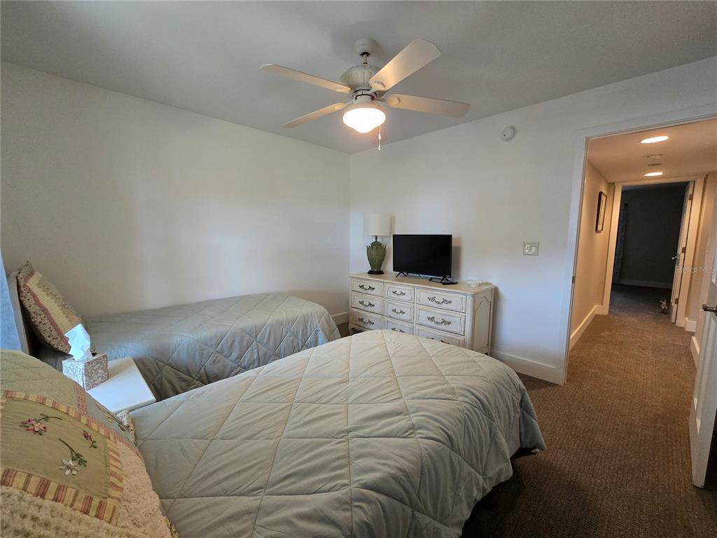 1640 Juno Trail, Unit 103C Astor, FL 32102 - Photo 13 of 20 a bedroom with two bed and a flat screen tv