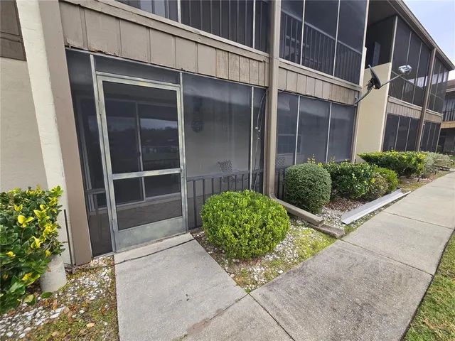 a view of a big house with a big yard and large trees