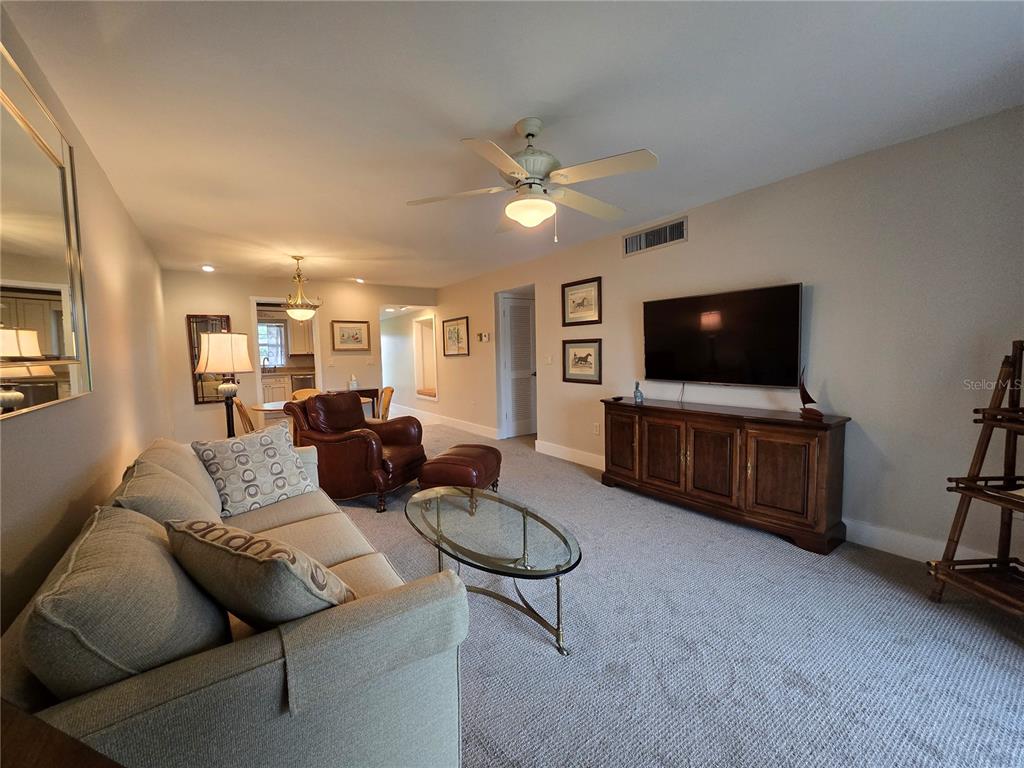 1640 Juno Trail, Unit 103C Astor, FL 32102 - Photo 4 of 20 a living room with furniture and a flat screen tv