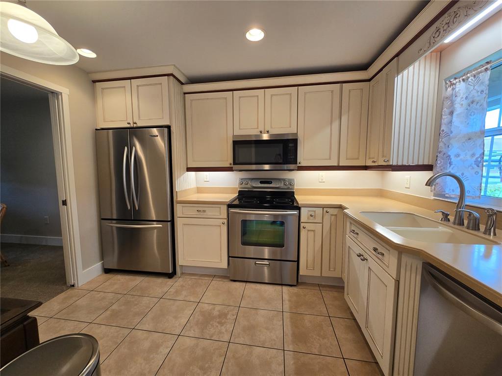 1640 Juno Trail, Unit 103C Astor, FL 32102 - Photo 7 of 20 a kitchen with a stove a sink and a refrigerator