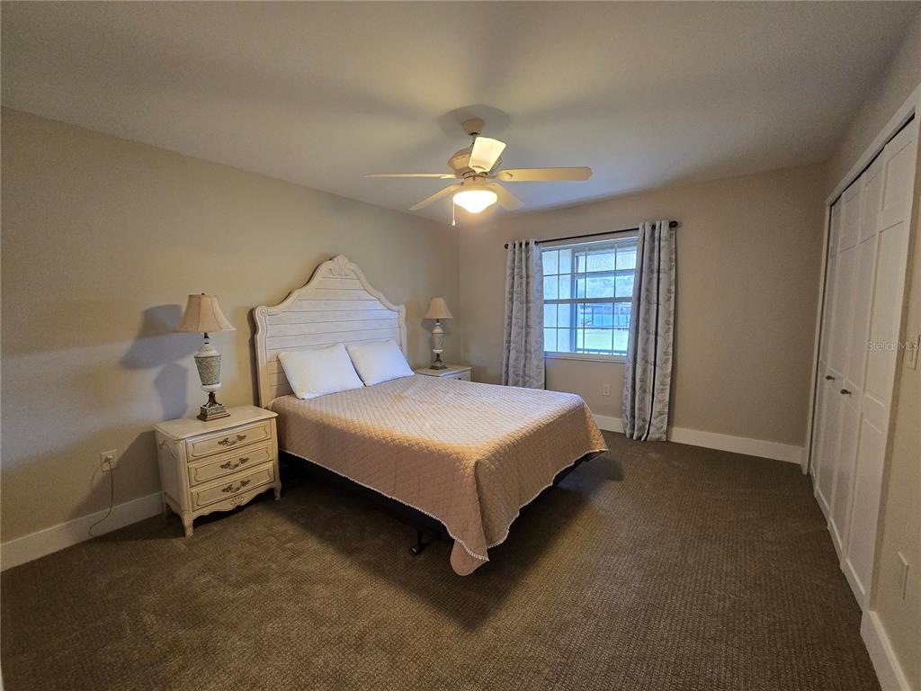 1640 Juno Trail, Unit 103C Astor, FL 32102 - Photo 9 of 20 a bedroom with a bed and a chandelier