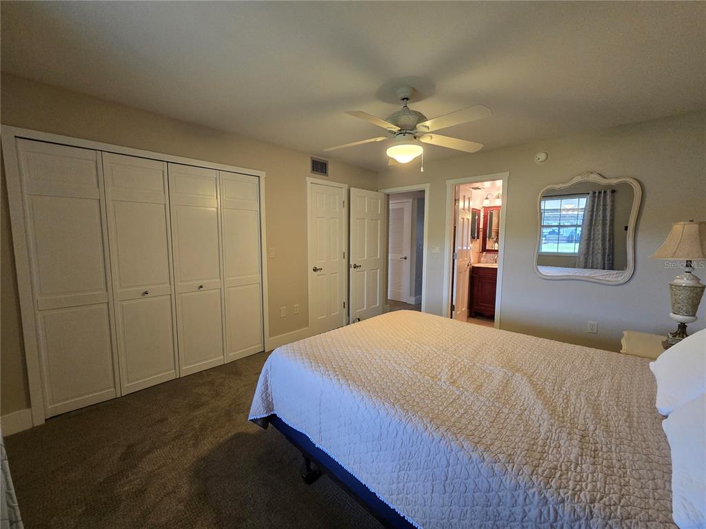 1640 Juno Trail, Unit 103C Astor, FL 32102 - Photo 10 of 20 a spacious bedroom with a bed and a chandelier
