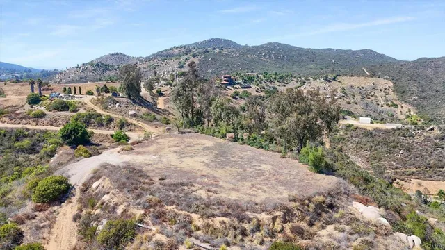 a view of a dry yard with mountains in the background