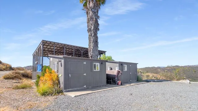 a view of a house with a small yard and large trees
