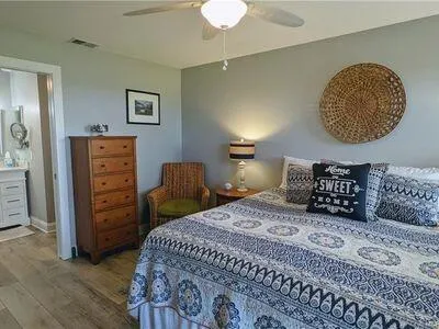 a view of a room with wooden floor a ceiling fan and a window