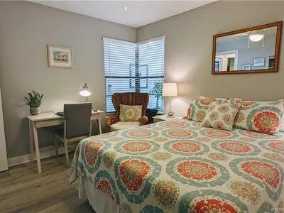 a bedroom with a bed and lamp on dresser