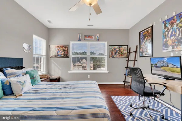 an empty room with a chandelier fan and windows