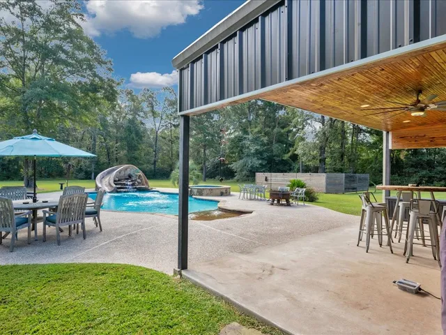 a view of a house with swimming pool and sitting area
