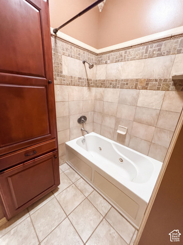 232 Bugle Way Providence, UT 84332 - Photo 13 of 36 Integrated soaking tub with shower, full-height tiled surround with mosaic accent, built-in wood cabinetry, and tile flooring