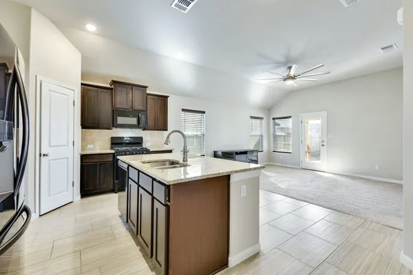 a kitchen with stainless steel appliances granite countertop a sink stove and refrigerator