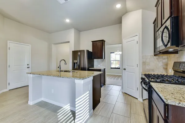 a kitchen with stainless steel appliances granite countertop a sink stove and refrigerator