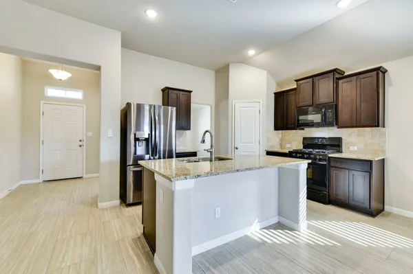 a kitchen with stainless steel appliances granite countertop a refrigerator stove and sink