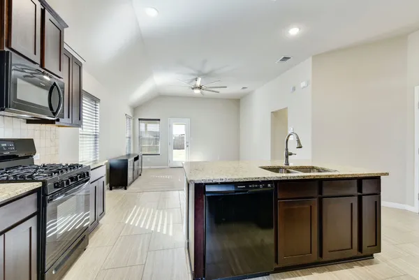 a kitchen with stainless steel appliances a sink stove and cabinets