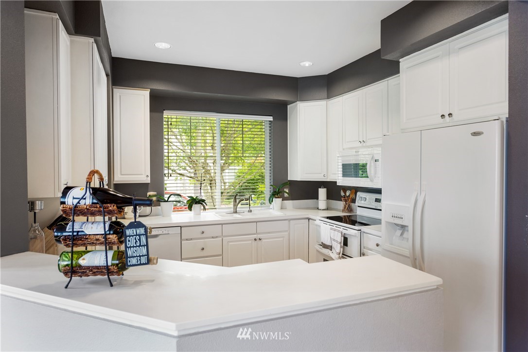 529 Chelan Place Northeast Renton, WA 98059 - Photo 6 of 20 a kitchen with a white cabinets and chairs