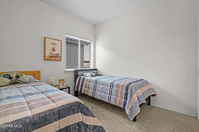 a bedroom with two beds and painting on the wall