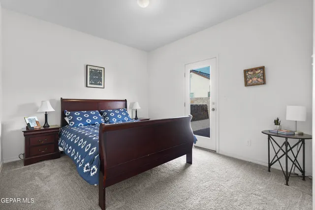 a bed sitting in a bedroom next to a window with a dresser