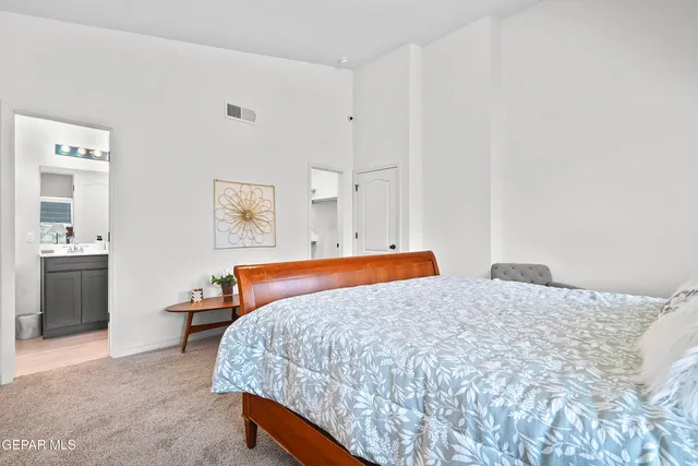 a bedroom with a bed and painting on the wall