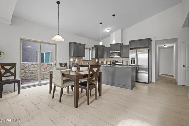 a view of a dining room and livingroom with furniture a chandelier