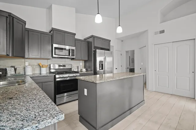 a kitchen with stainless steel appliances granite countertop a sink stove and refrigerator
