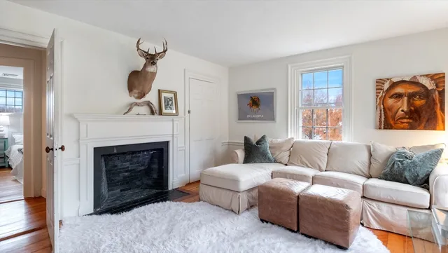 a living room with furniture a fireplace and a window