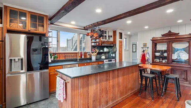 a kitchen with stainless steel appliances granite countertop a refrigerator and a wooden cabinets