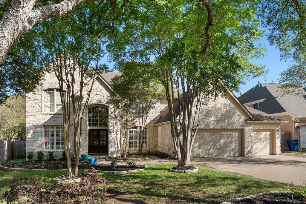 5306 Austral Loop Austin, TX 78739 - Photo 1 of 1 French provincial home featuring an attached garage, french doors, concrete driveway, and stone siding