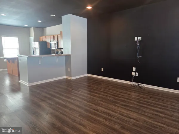 a view of a kitchen with kitchen island wooden floor and appliances
