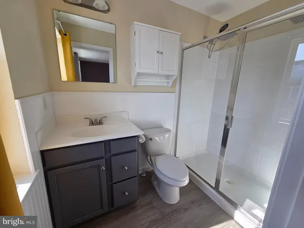 a bathroom with a sink a toilet a mirror and shower