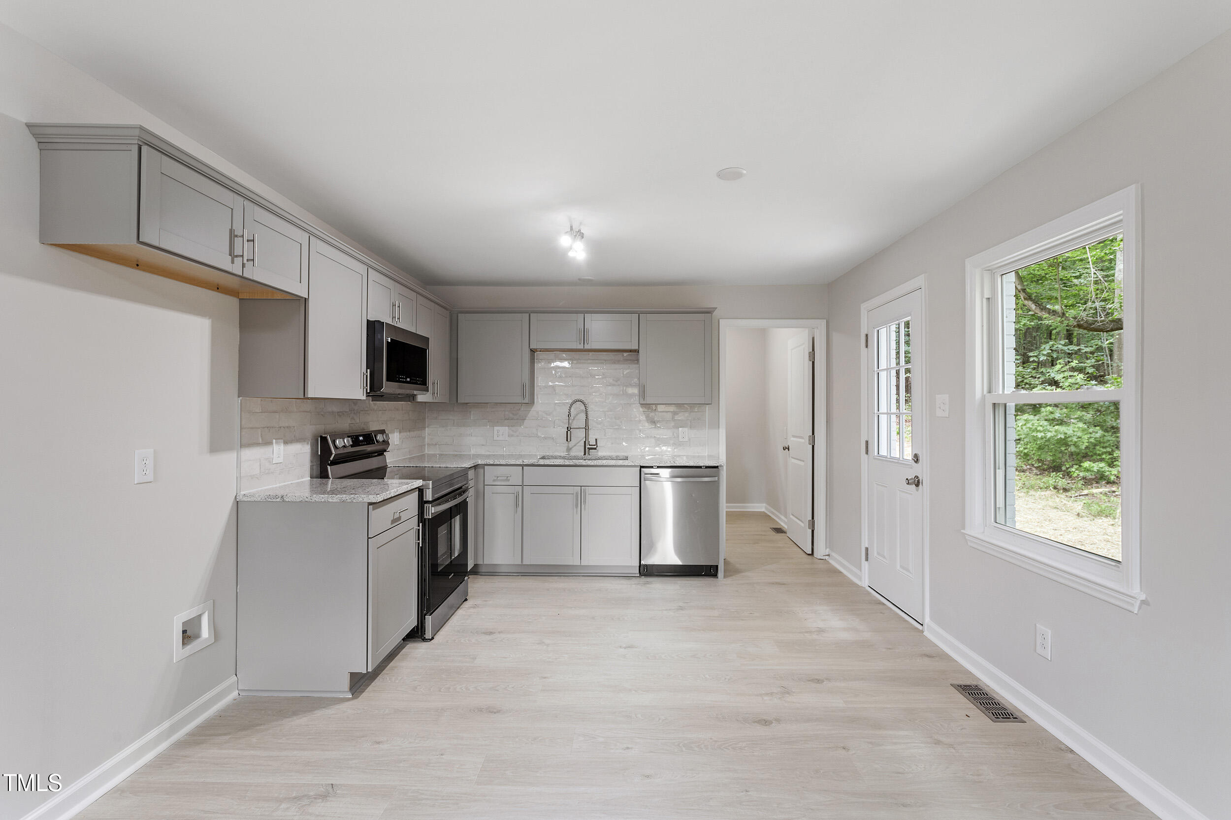 a kitchen with a sink a window and stainless steel appliances