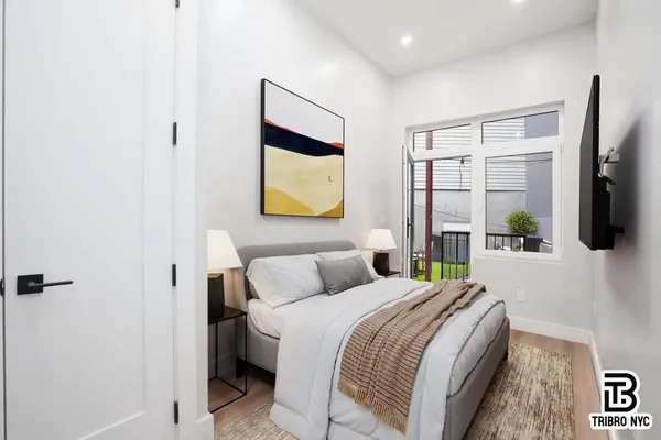 a bedroom with a bed a flat screen tv and painting on the wall