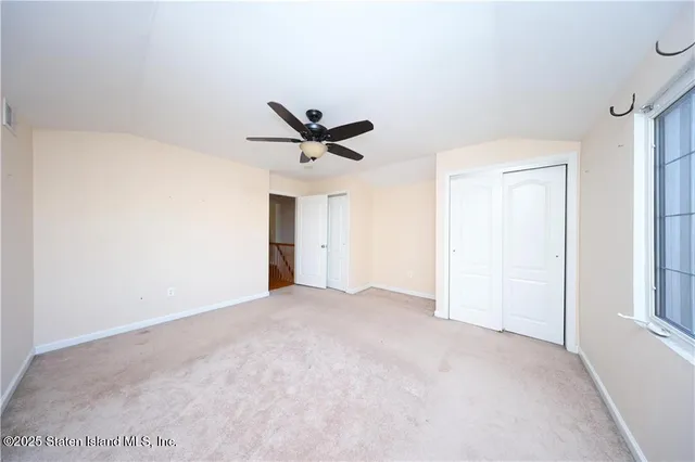 a view of a livingroom with a ceiling fan and window