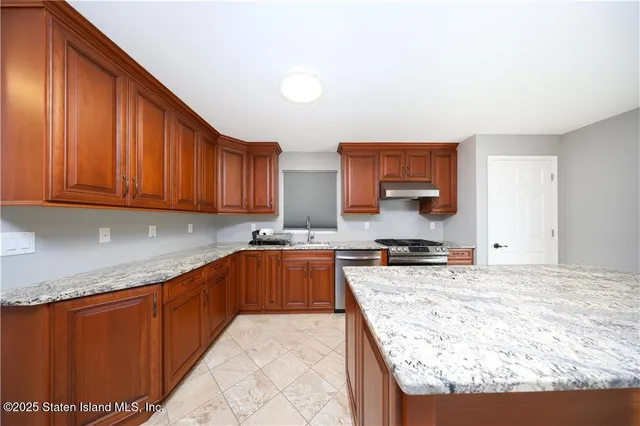 a kitchen with stainless steel appliances granite countertop a sink stove and cabinets