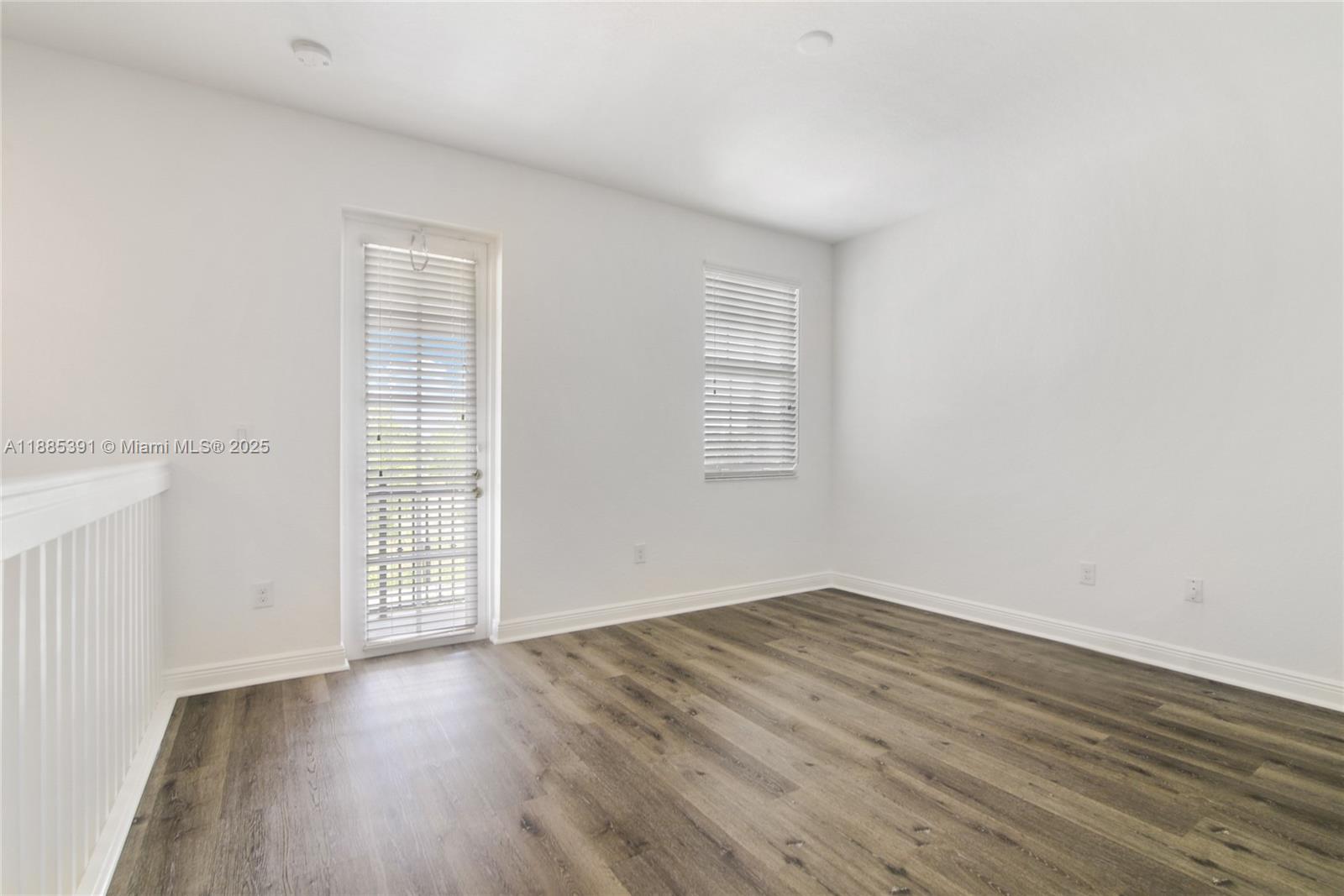1108 Southwest 146th Terrace Pembroke Pines, FL 33027 - Photo 10 of 14 an empty room with wooden floor and windows