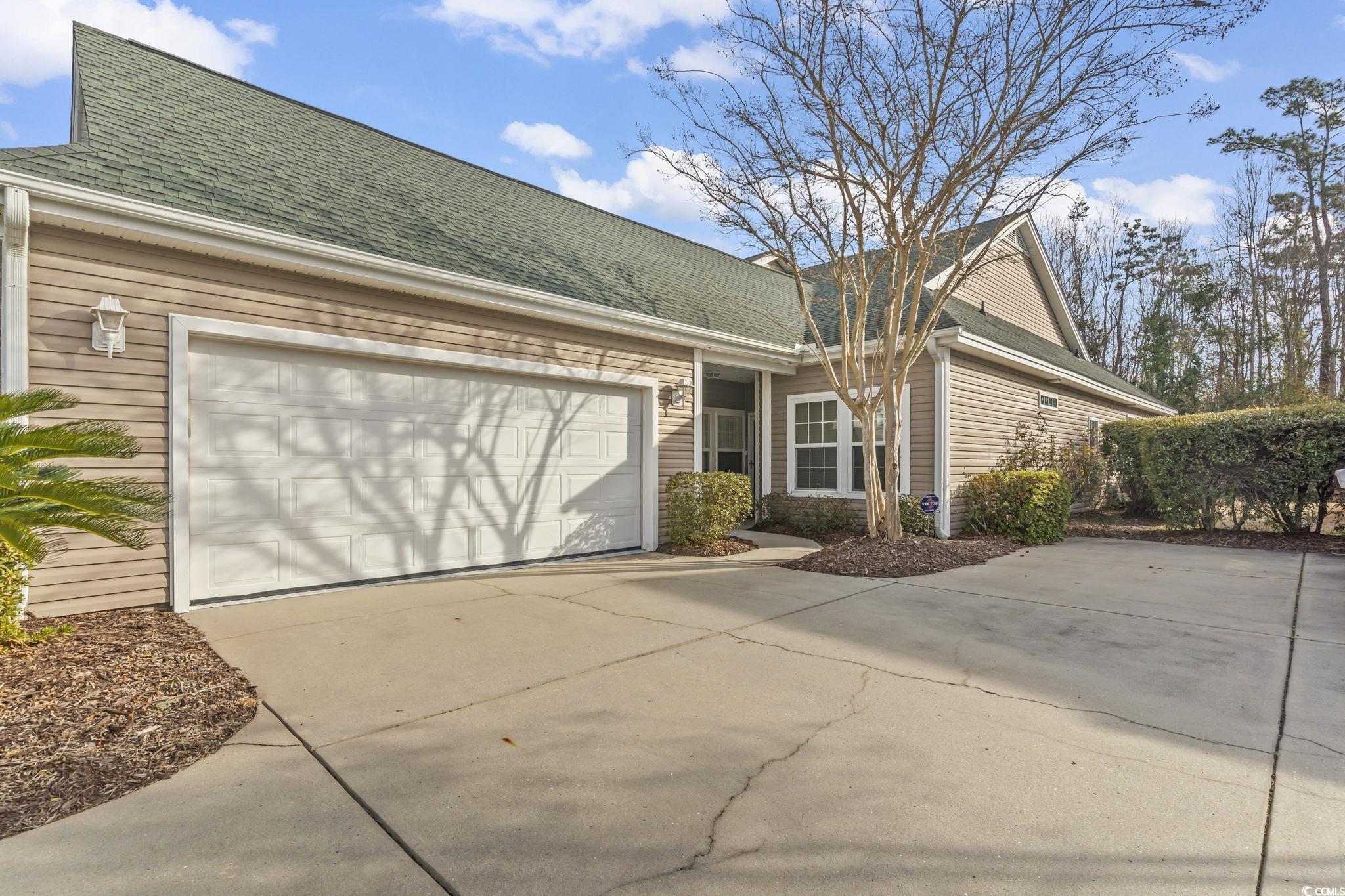 430 Woodpecker Lane, Unit D Murrells Inlet, SC 29576 - Photo 1 of 36 View of front of property with a shingled roof, concrete driveway, and an attached garage
