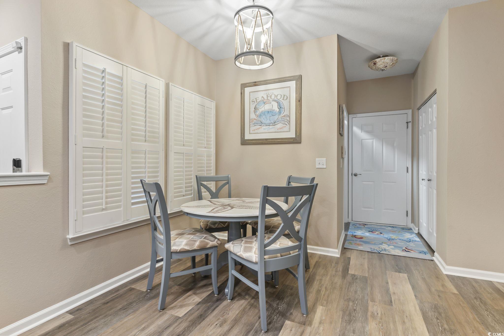 430 Woodpecker Lane, Unit D Murrells Inlet, SC 29576 - Photo 8 of 36 Dining space with light wood-style floors and a chandelier