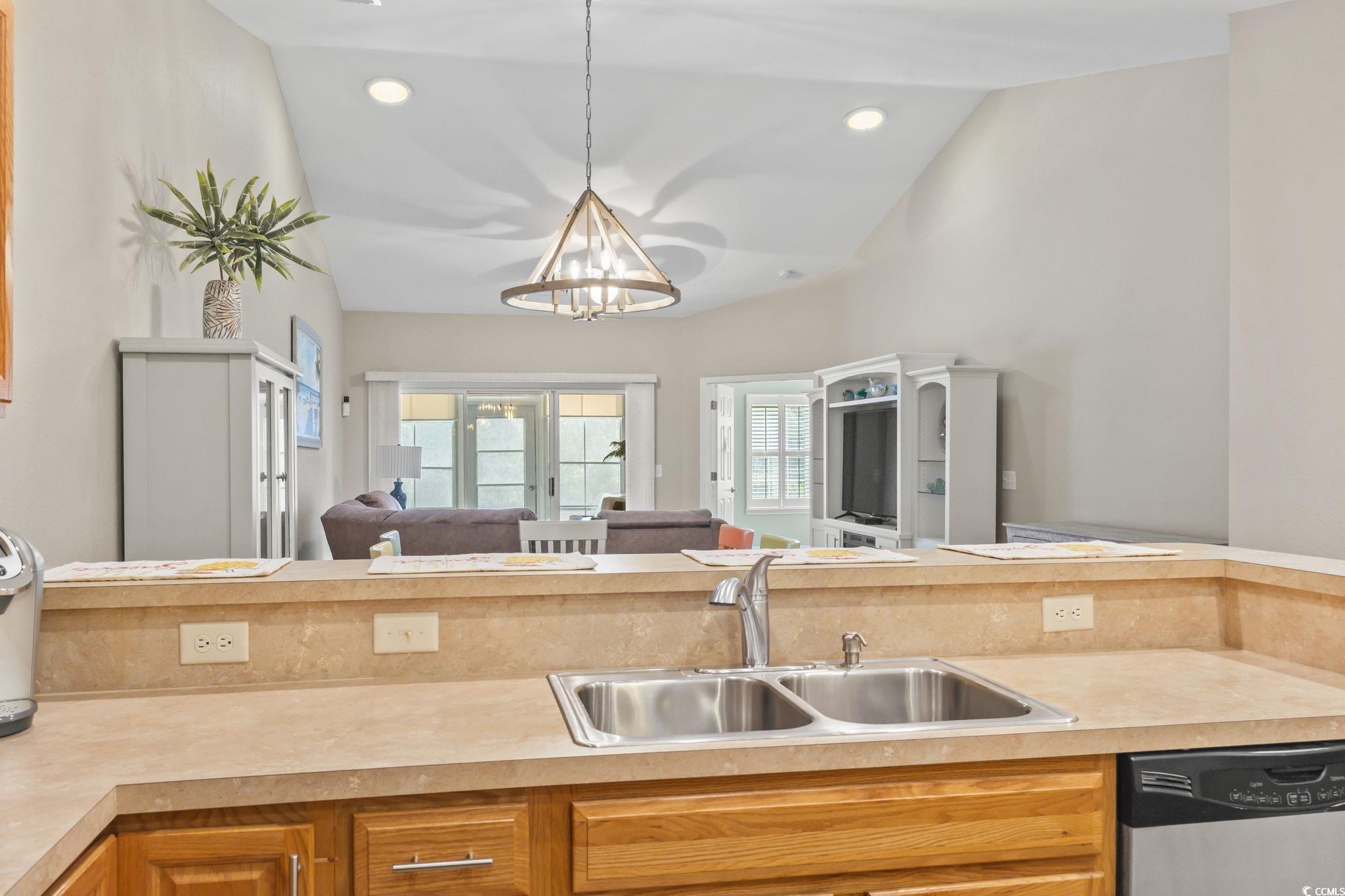 430 Woodpecker Lane, Unit D Murrells Inlet, SC 29576 - Photo 35 of 36 Kitchen with light countertops, open floor plan, dishwasher, brown cabinets, and lofted ceiling
