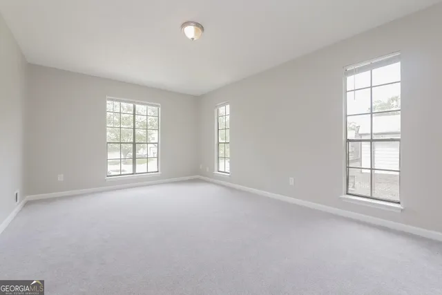 an empty room with windows and closet