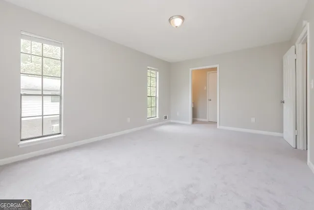 an empty room with windows and closet