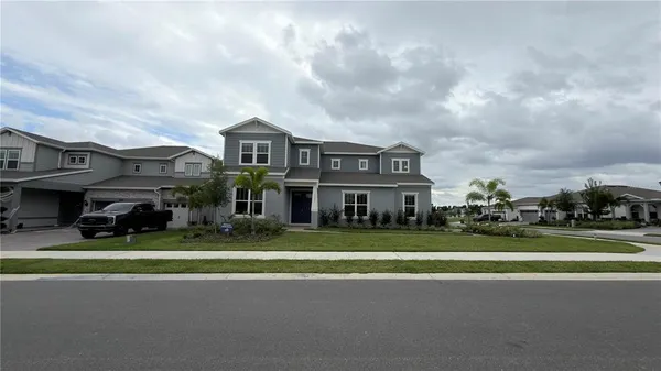 a view of a big house with a big yard and large trees