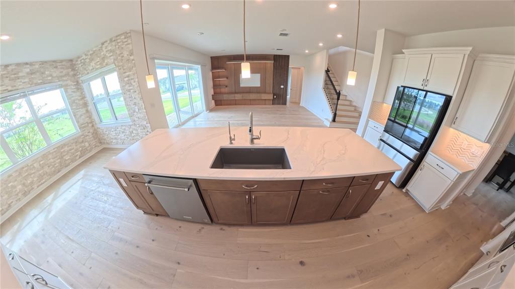 15295 Rising Vw Drive Montverde, FL 34756 - Photo 4 of 50 a kitchen with stainless steel appliances a dining table wooden floor a large window and white cabinets