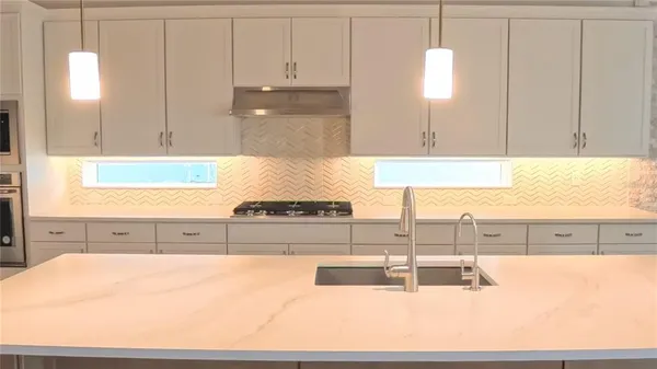 a large kitchen with kitchen island a sink stainless steel appliances and cabinets