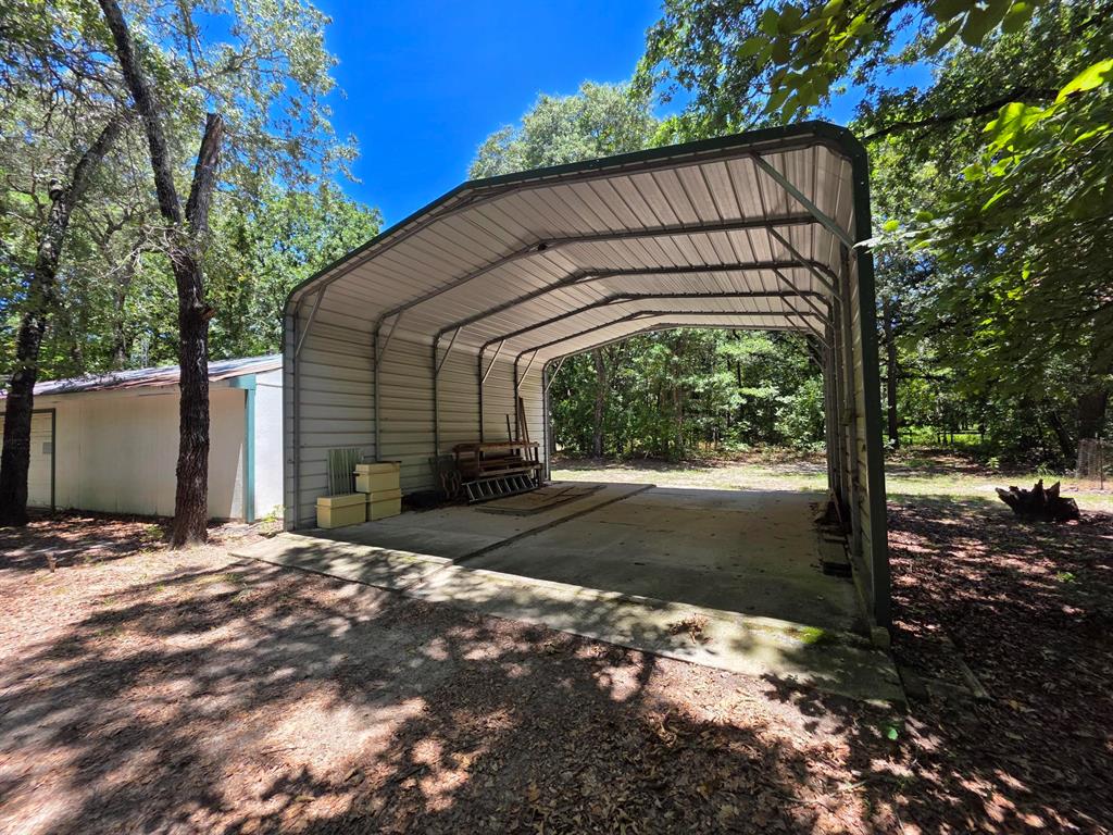 3872 East State Highway 154 Quitman, TX 75783 - Photo 7 of 40 a backyard of a house with large trees and a small yard