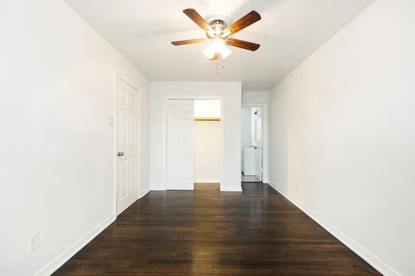 a view of an empty room with wooden floor