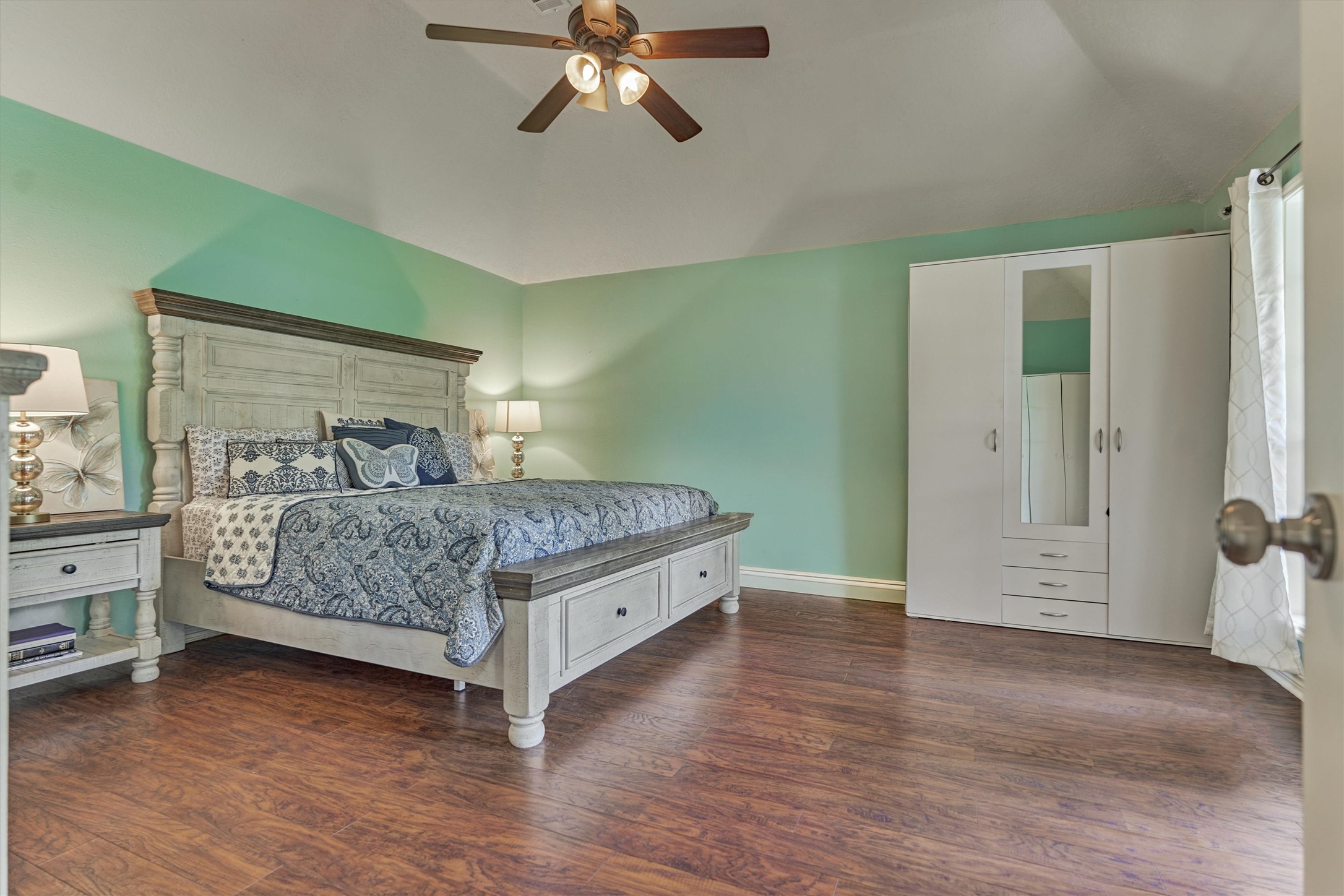 25706 Overlake Drive Spring, TX 77380 - Photo 15 of 32 Spacious master bedroom featuring elegant wood floors, abundant natural light, and a stylish ceiling fan.